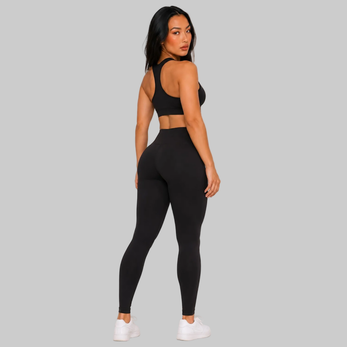 Model wearing DonDeMarco black high waist 7/8 active leggings, shown with matching bra top