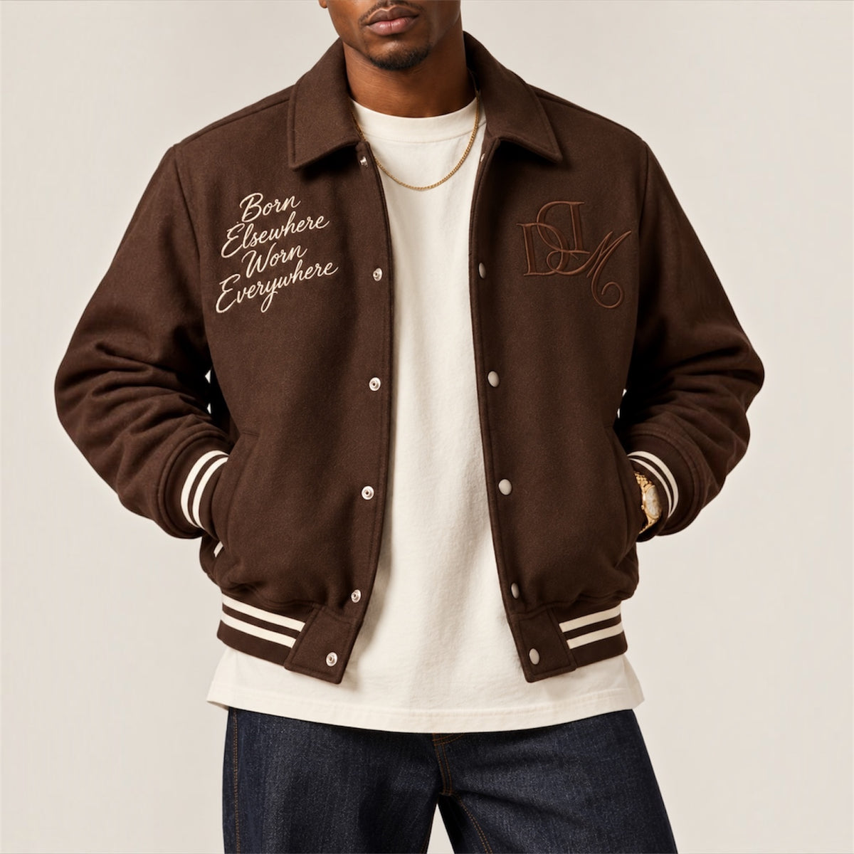 Detail of embroidery, snap buttons and striped ribbing on DonDeMarco varsity jacket