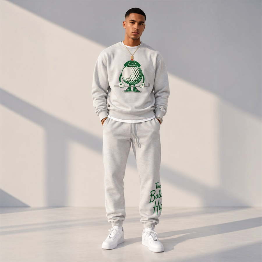 Model wearing the white heather DonDeMarco Baldwin Hills Country Club Golf Edition sweatshirt and sweatpants set, full-body front view