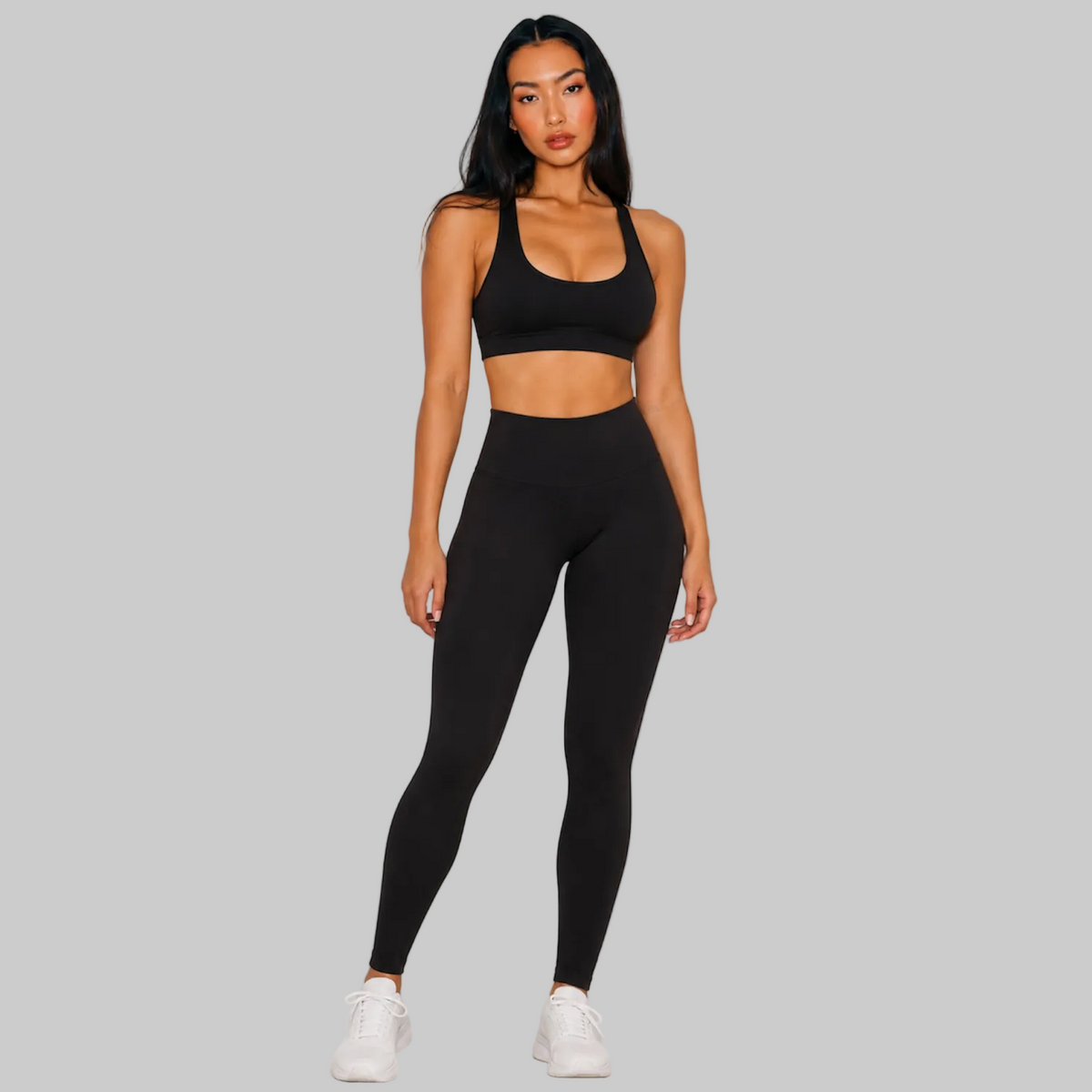 Model wearing DonDeMarco black high waist 7/8 active leggings, shown with matching bra top