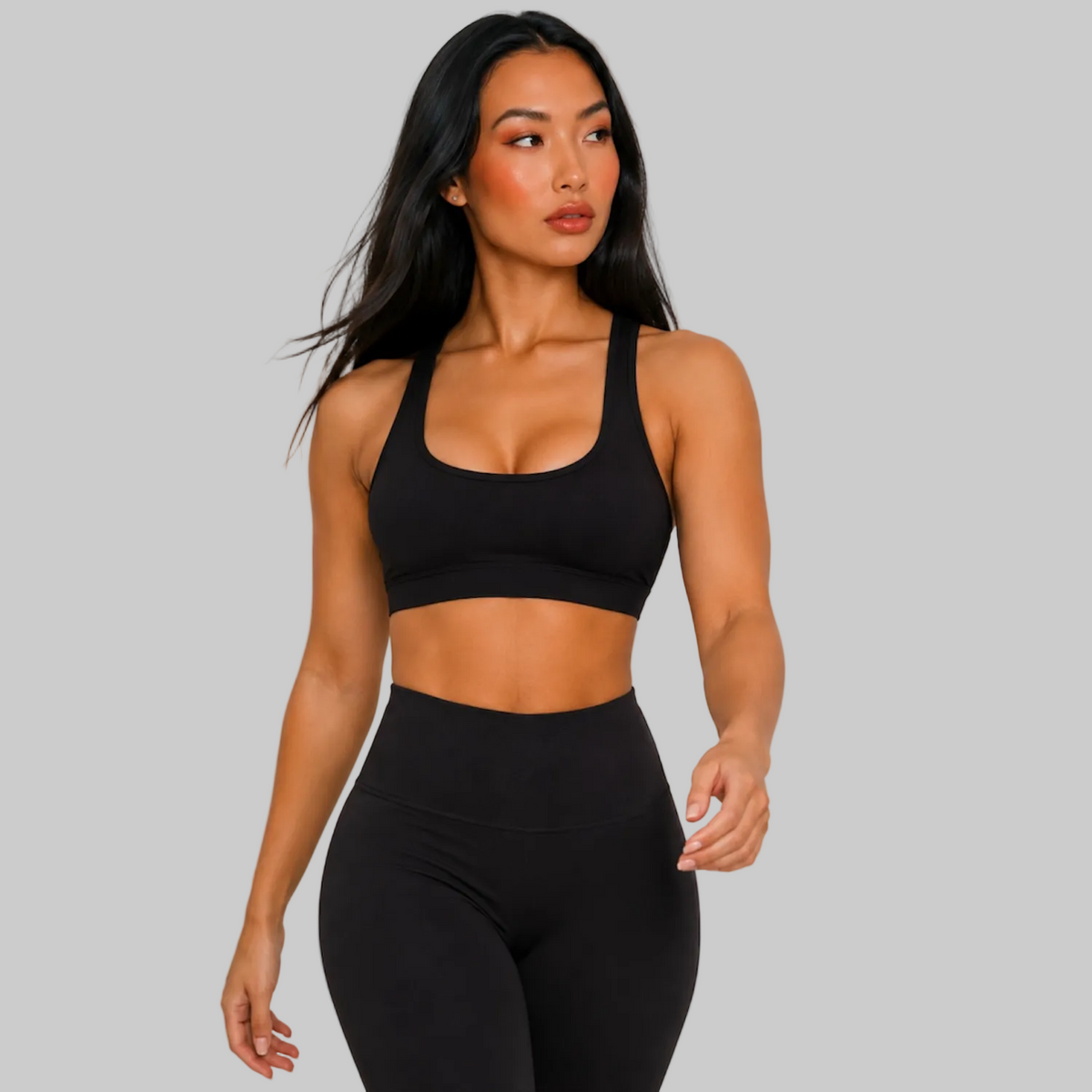 Model wearing DonDeMarco black high waist 7/8 active leggings, shown with matching bra top
