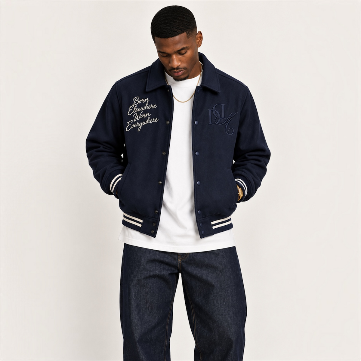 Model looking down wearing DonDeMarco navy varsity wool jacket