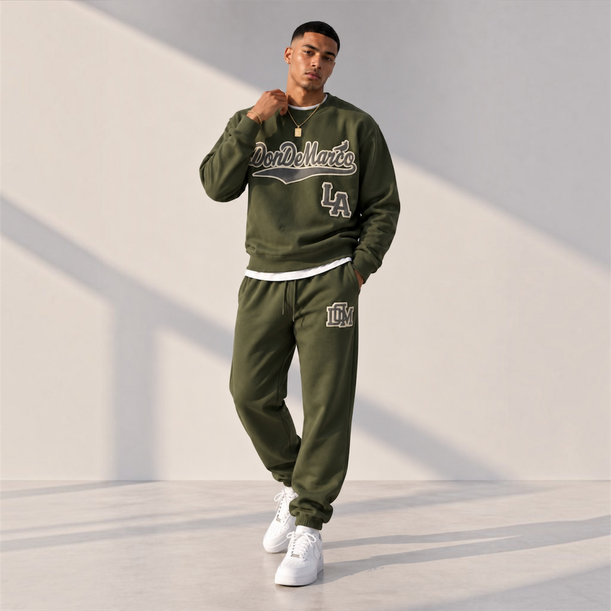 Model wearing the DonDeMarco Script Logo Olive Crewneck Set with white sneakers, full-body editorial view